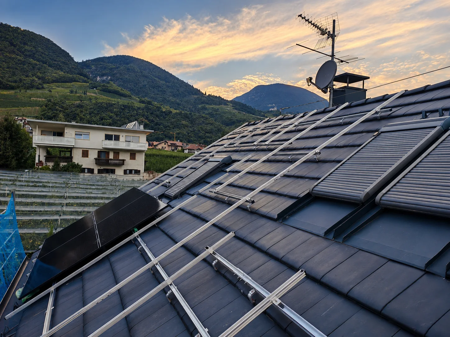 Guide di montaggio fotovoltaico su tetto scuro al tramonto