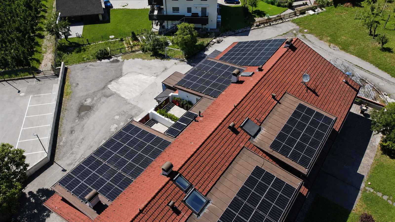 Grande tetto rosso con numerosi campi fotovoltaici visto dal drone